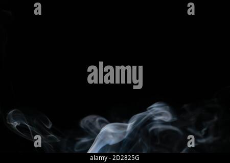 Abstract smoke background with copy space on black background. Blue-white smoke rising from the incense stick Stock Photo