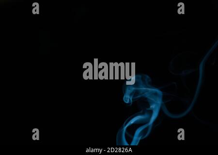 Beautiful abstract blue smoke with copy space on black background. Smoke background for art design or drawing. Abstract figure of the smoke Stock Photo