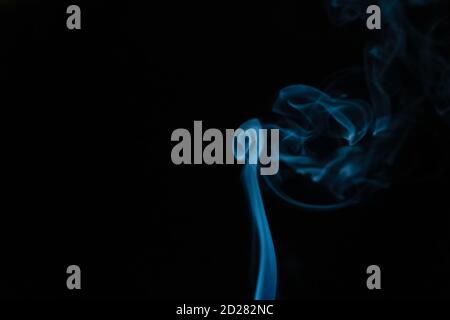 Beautiful abstract blue smoke with copy space on black background. Smoke background for art design or drawing. Abstract figure of the smoke Stock Photo