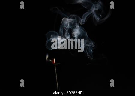 abstract background of smoke from incense stick close up with copy of space on black background. Focus on the smoke Stock Photo