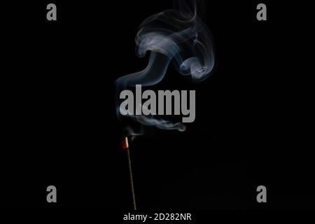 abstract background of smoke from incense stick close up with copy of space on black background. Focus on the smoke Stock Photo