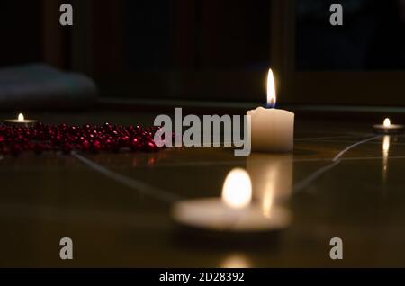 pentagram is painted on the floor, candles are lit, beads are lying, shells are scattered. concept of magic with occult and esoteric symbols. Stock Photo