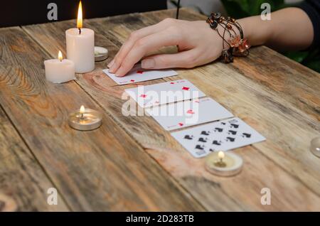 Hand fortune teller, cards, candles on a wooden table. concept of divination, magic. Stock Photo