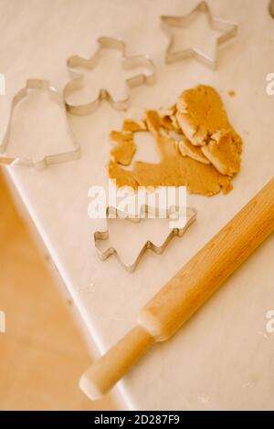 The process of making gingerbread cookies - rolling pin, molds and dough on a white table. Stock Photo