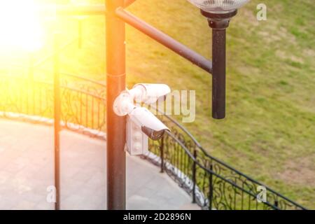 two white CCTV cameras on a pole in the Park Stock Photo