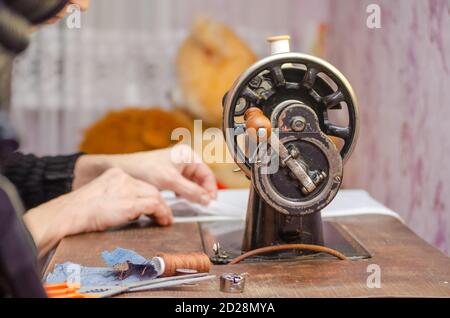 Old vintage hand sewing machine. Woman at work on a sewing machine Stock Photo