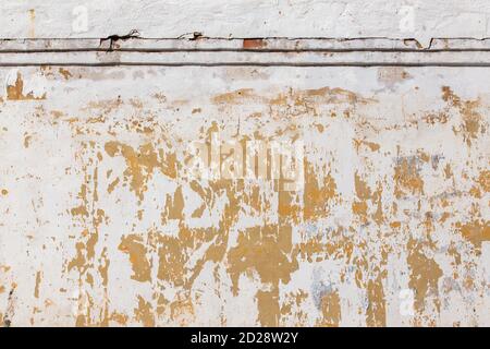 Shabby flat plaster and painted wall with big yellow under layer spots Stock Photo
