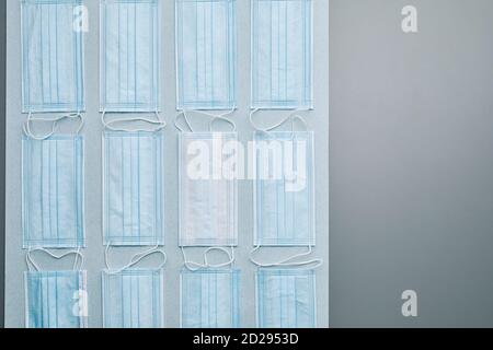 Flat lay composition of medical masks laid out in pattern over grey background, copy space Stock Photo