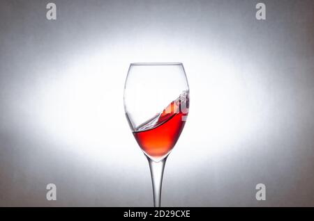 glass of red wine on a white background in motion. Freezing liquids in motion Stock Photo