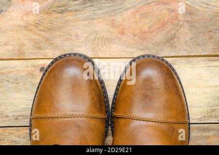 Rounded nose of men's brown shoes on a wooden background close-up with a copy of the space. view top Stock Photo