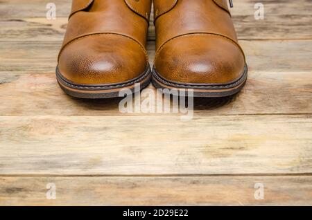 Rounded nose of men's brown shoes on a wooden background close-up with a copy of the space Stock Photo