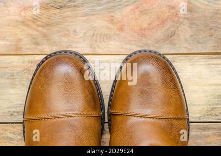 Rounded nose of men's brown shoes on a wooden background close-up with a copy of the space. view top Stock Photo