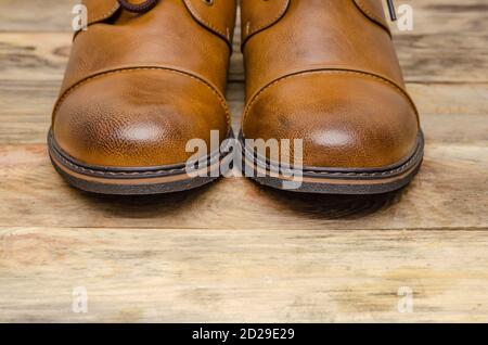 Rounded nose of men's brown shoes on a wooden background close-up with a copy of the space Stock Photo