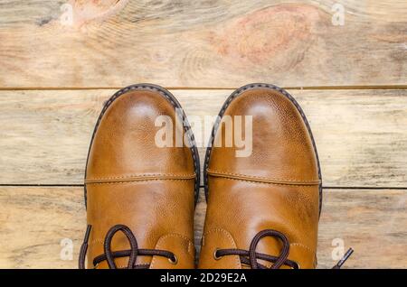 Rounded nose of men's brown shoes on a wooden background close-up with a copy of the space. view top Stock Photo