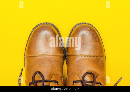 Rounded nose of men's brown shoes on a yellow background close-up with a copy of the space Stock Photo