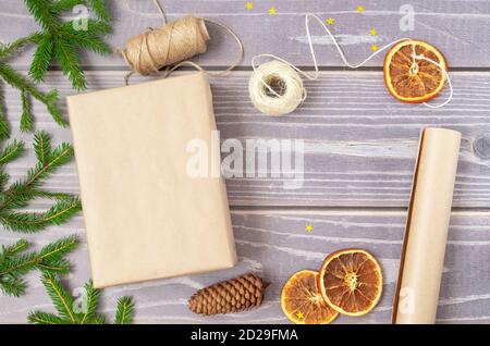 Close-up of packing a Christmas gift. Christmas decor and recyclable packaging materials. Stock Photo