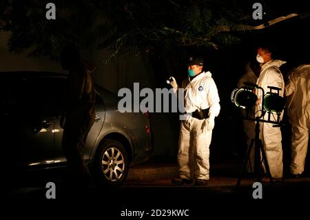 Forensic workers inspect a car in the suburb of San Nicolas in the northern city of Monterrey November 21, 2007. Police found the body of a man, with part of his body covered with tape in the trunk of the car. About 102 people have been killed, including 29 policemen, since the beginning of the year in a wave of violence in the business city, according to local media. Picture taken November 21, 2007. REUTERS/Tomas Bravo (MEXICO)