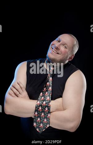 Emotional comic actor gesturing man in a tie on a black background, Christmas and New Year Stock Photo