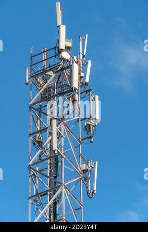 Mobile communication tower close-up against the blue sky, vertical photo Stock Photo