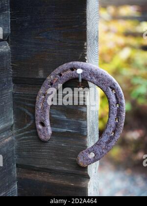 Horsehoe hanging on a nail on cabin porch. Stock Photo