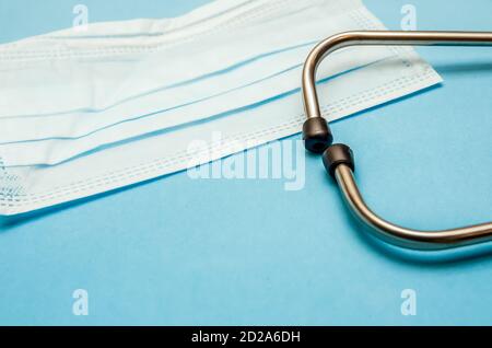 Medical mask, white tablets, phonendoscope on a blue background with a copy space Stock Photo
