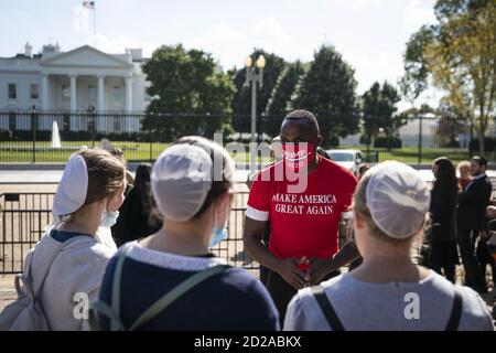 Washington, United States. 06th Oct, 2020. A man wearing a Make America Great Again shirt and protective face mask speaks to a group of people outside of the White House in Washington, DC, U.S., on Tuesday, Oct. 6, 2020. Photo by Sarah Silbiger/UPI Credit: UPI/Alamy Live News