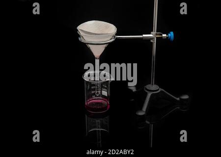 Filter paper in laboratory. Scientists are chemical filtration by filtering through filter paper in a glass funnel, Close up Stock Photo