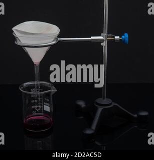 Filter paper in laboratory. Scientists are chemical filtration by filtering through filter paper in a glass funnel, Close up Stock Photo
