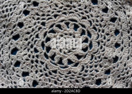 Full frame macro texture background of a white hand crocheted doily texture on dark blue background, with copy space Stock Photo