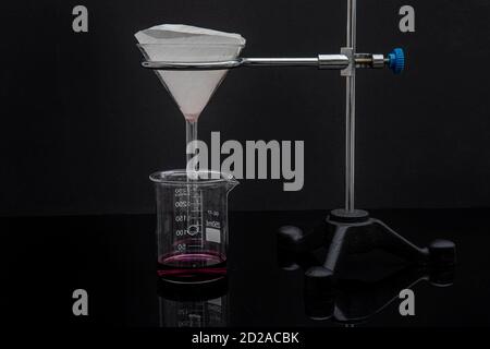 Filter paper in laboratory. Scientists are chemical filtration by filtering through filter paper in a glass funnel, Close up Stock Photo