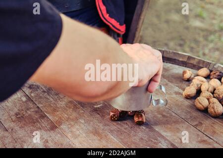 Man hand throw dice on a barrel. People in ancient costumes pour out dice from an iron mug on a table from a wooden barrel Stock Photo