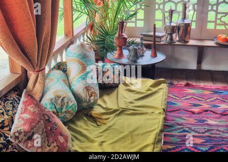 Interior of mobile Turkish vintage tent. Decoration of houses of the Ottoman Empire of the 18th or 19th century - hookah, pitchers, curtains, coffee a Stock Photo