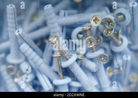 Screws with dowels in a plastic jar, close-up background Stock Photo