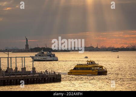 Water taxi in New York harbor with the Statue of Liberty NYC Stock Photo