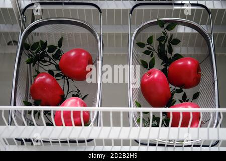 Red artificial apples in a metal basket Stock Photo