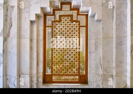 Arabic style wooden window and a white marble wall. Pattern shutters without glass. Interior design element in hotel Tunis, middle East. Stock Photo