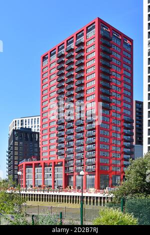 A high rise red apartment block on brownfield site City Island development of new homes & offices beside River Lee Creek Canning Town East London UK Stock Photo