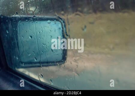 Water drops on the passenger side window and mirror of the car. Stock Photo