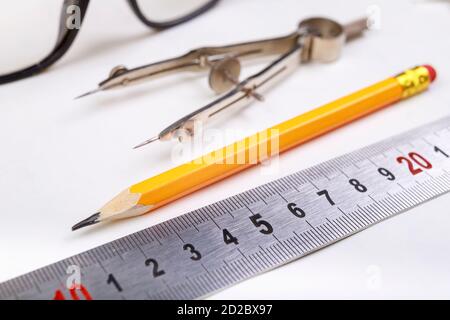 View of the accessories of the Craftsman Engineer. Accessories for building design work on wooden table. Light background. Stock Photo