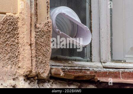 Plastic pipe for ventilation sticking out of the window close-up Stock Photo