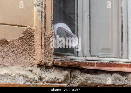 Plastic pipe for ventilation sticking out of the window close-up Stock Photo