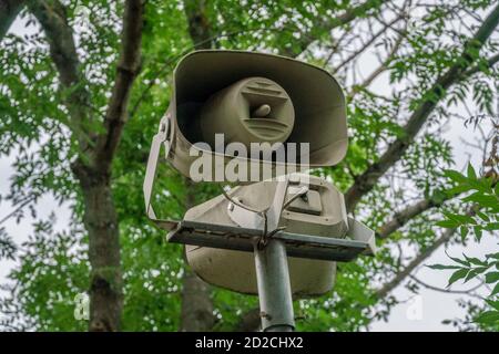Loudspeaker on the background of green trees in the park closeup Stock Photo