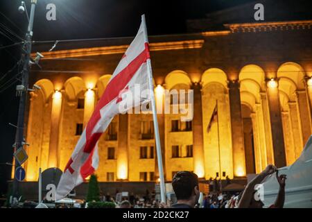 Tbilisi, Georgia - June 29 2019: Georgian flag on the background of the parliament in Tbilisi at night during the rally Stock Photo