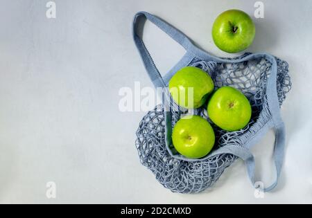 Several green apples are in a string bag. Stock Photo