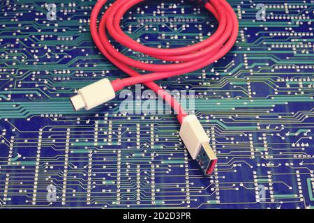 Red usb wire against electronic circuit board Stock Photo