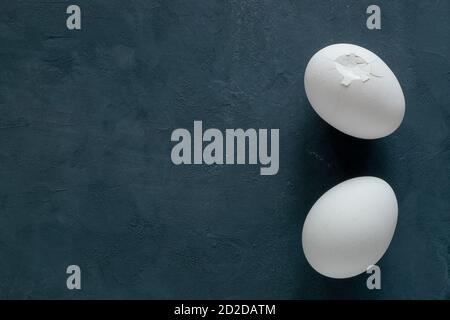 Two white broken chicken eggs on a black background Stock Photo