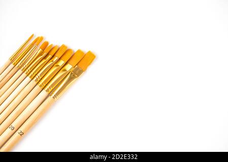 New brushes of different sizes on a wooden handle isolated on white background. Stock Photo