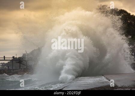 Huge stormy waves crashing near the city embankment. Big sea wave splash. Giant waves on a stormy day in Yalta. Power of nature, storm Stock Photo