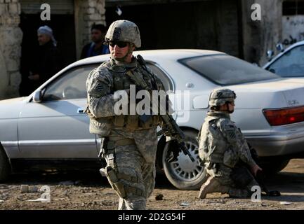U.S. soldiers take up position near a vehicle during a joint patrol with Iraqi security forces in Jasr Diyala on the outskirts of southern Baghdad December 4, 2007.   REUTERS/Erik de Castro       (IRAQ)