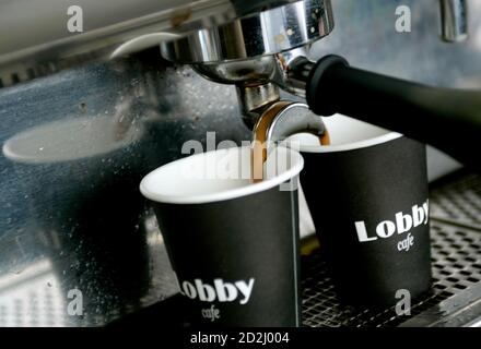 Coffee pours into cups from a machine at a coffee stand in central Sydney September 13, 2007. Australian coffee consumption boomed to 2.4 kilograms a head, or 1.26 billion cups a
